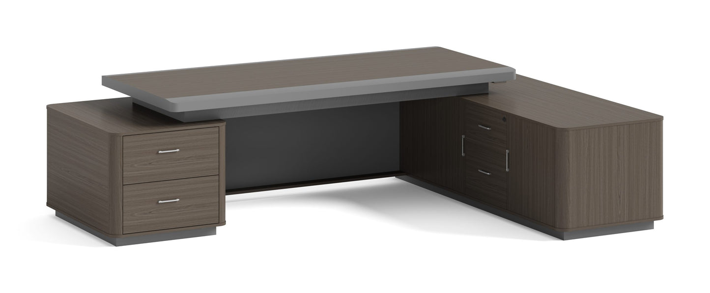 Modern L-shaped melamine office desk with built-in credenza, featuring a dark wood finish and two drawers on the left side. The desk has a minimalist design and includes a raised tabletop for a sleek, professional look